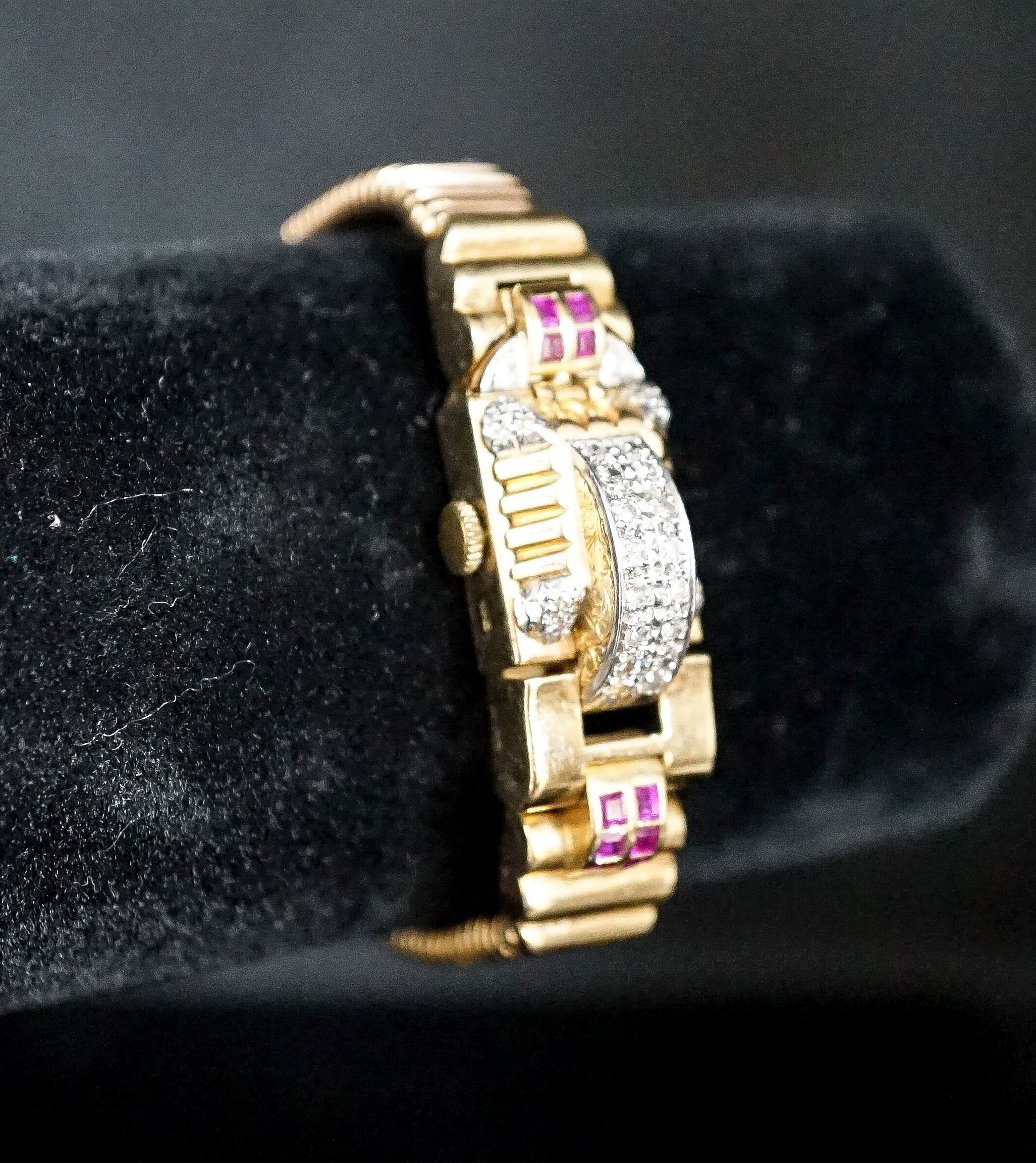 A 1950's 9ct gold, ruby and diamond set Emka manual wind cocktail watch, the dial with gem set hinged cover, gross weight 37.2 grams.